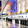 Wide view of Chicago airport terminal showcasing architecture and check-in counters. Flags and signages add vibrant detail.